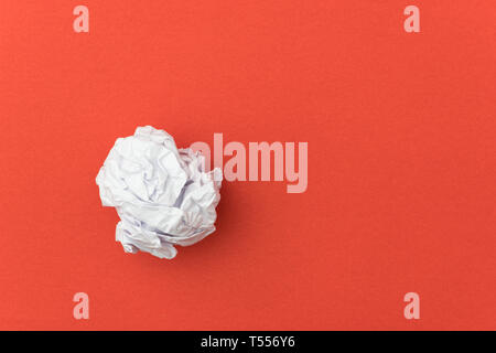 Carta sgualcita sfera su sfondo rosso per il concetto di business. Foto Stock