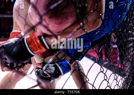 Il concetto di sport di combattimento senza regole. Due lottatori di atleta nell'arena della scena ottagonale. Umore combatte senza regole boxe MMA. Alternativa Foto Stock