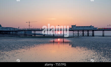 Worthing Sussex, Regno Unito; xx aprile 2019; Dawn con il sorgere del sole dietro a Worthing Pier a bassa marea Foto Stock