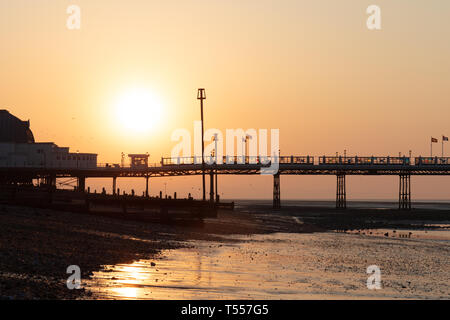 Worthing Sussex, Regno Unito; xx aprile 2019; Dawn con il sorgere del sole dietro a Worthing Pier a bassa marea Foto Stock