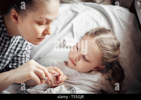 Madre premurosa tagliare le unghie di una bambina Foto stock - Alamy