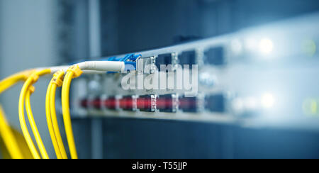 Banner di tecnologia. Chiudere il cavo a fibra ottica. Server rack. Taglia il computer in un rack presso il centro dati di grandi dimensioni. Foto contiene il rumore Foto Stock