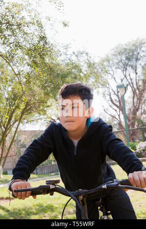 Ragazzo Bicicletta Equitazione in posizione di parcheggio Foto Stock