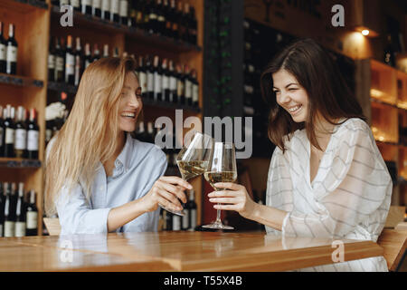 Giovani donne la tostatura con bicchieri di vino bianco Foto Stock