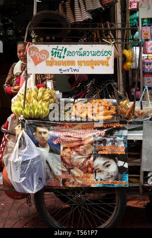 Thailandia, Bangkok Chinatown, Thanon Mangkon, street food, donna con mobile, fritti banana snack in stallo Foto Stock