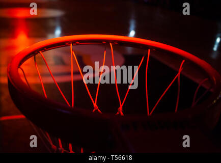 Basketball hoop in rosso le luci al neon in arena sportiva durante il gioco - Concorrenza Foto Stock