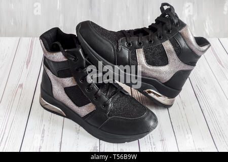 Confortevole sneakers nero con pannelli grigio sulla piattaforma alta con una cerniera lampo e lace-up. Foto Stock