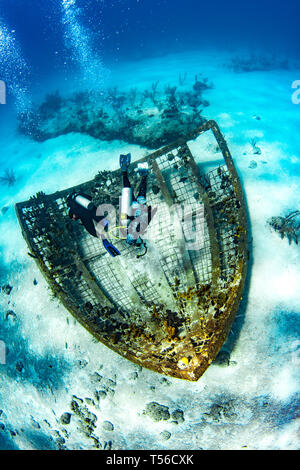 I subacquei esplorare ciò che resta del tuono-dome, ora un reef artificiale nelle Isole Turks e Caicos. Foto Stock