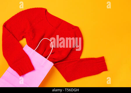 Vista superiore della rosa shopping bag con red swether Foto Stock