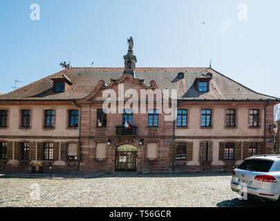 Bergheim, Francia - 19 Apr 2019: vista anteriore del Hotel de Ville municipio nella piazza centrale di un ampio angolo di visione con la bandiera francese sventola sopra la porta di ingresso Foto Stock