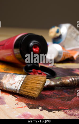 Artista spazzole, rosso tubo di vernice e la vernice verticale della tavolozza Foto Stock