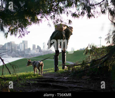 Ragazza escursionismo nel Parco urbano con il cane al guinzaglio Foto Stock