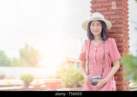 Giovani Hipster sorriso e tenendo la fotocamera vintage, il concetto di viaggio Foto Stock