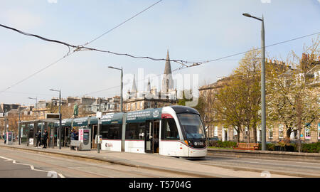 Un Urbos 3 tram presso il West End - Princes Street light railway station con Coates terrazza, il William Gladstone monumento e St Mary's Cathdral in t Foto Stock