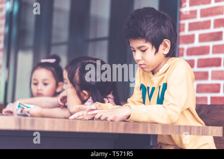 Asilo nido dei bambini che giocano con il conteggio carta nella camera di classe Foto Stock