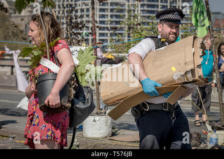 Londra, Regno Unito. Xxi Aprile, 2019. La polizia inizia a rompere e chiara estinzione della ribellione manifestanti' camp su Waterloo Bridge tenendo lontano piante, tende e altre infrastrutture di camp. Più di mille persone sono state arrestate durante i sei giorni di cambiamento climatico proteste. Centinaia di funzionari di altre forze che sono state inviate al capitale per aiutare la polizia metropolitana. Credito: Guy Corbishley/Alamy Live News Foto Stock