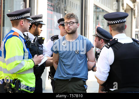 Un attivista ambientale è visto di essere arrestato dai poliziotti presso la Oxford Circus durante il quinto giorno del cambiamento climatico protesta da parte di la ribellione di estinzione Gruppo movimento Un grande numero di presenza della polizia intorno al rosa yacht come essi ONU-bond gli attivisti che incollati stessi e la polizia si prepara a rimuoverli dal sito. Secondo la polizia si è riunito, oltre mille militanti sono stati arrestati poiché la dimostrazione è iniziato il 11 aprile 2019. Foto Stock