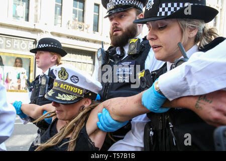 Un attivista ambientale è visto di essere arrestato dai poliziotti presso la Oxford Circus durante il quinto giorno del cambiamento climatico protesta da parte di la ribellione di estinzione Gruppo movimento Un grande numero di presenza della polizia intorno al rosa yacht come essi ONU-bond gli attivisti che incollati stessi e la polizia si prepara a rimuoverli dal sito. Secondo la polizia si è riunito, oltre mille militanti sono stati arrestati poiché la dimostrazione è iniziato il 11 aprile 2019. Foto Stock