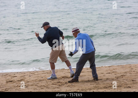 Bournemouth Dorset, Regno Unito. 22 apr 2019. Regno Unito meteo: dopo un inizio nebuloso il glorioso meteo continua con caldo e soleggiato, come testa beachgoers al mare per godere del calore e del sole a Bournemouth spiagge del Lunedì di Pasqua prima che i cambiamenti climatici e il ritorno al lavoro. La mattina presto esercizi sulla riva del mare - due vecchi vecchi uomini anziani facendo tai chi esercita all'aperto sulla spiaggia. Credito: Carolyn Jenkins/Alamy Live News Foto Stock