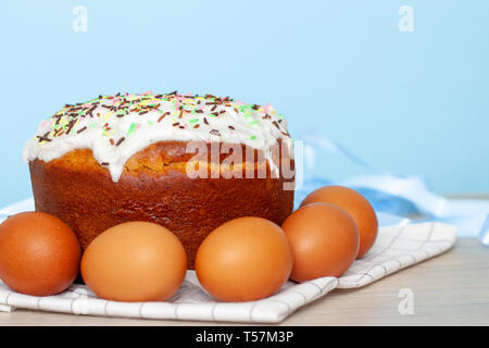 Torta di Pasqua e uova colorate su sfondo blu. Cibo per le vacanze di Pasqua e concetto. Messa a fuoco selettiva. Copyspase. Foto Stock