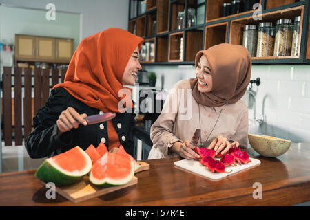 Donna musulmana amico preparare alcuni dessert di frutta cocktail Foto Stock