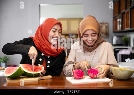 Donna musulmana amico preparare alcuni dessert di frutta cocktail Foto Stock