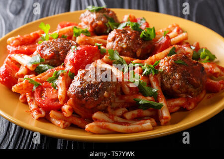 La pasta italiana Le Casarecce con polpettine di carne in salsa di pomodoro closeup su una piastra sul tavolo orizzontale. Foto Stock