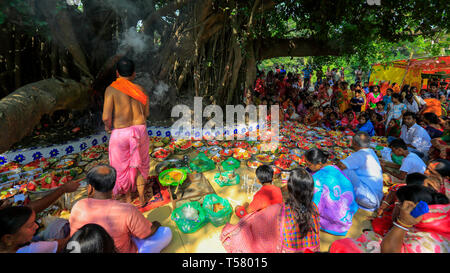 Devoti di sedersi accanto a schiere di offerte di servizi posti sotto le antiche banyan tree, che è adorato dagli Indù locale il primo giorno dell anno bengalese. Na Foto Stock