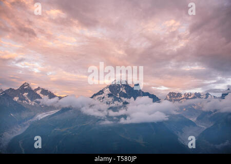 Nuvoloso Tramonto iconico Mont-Blanc gamma di montagne e ghiacciai Foto Stock