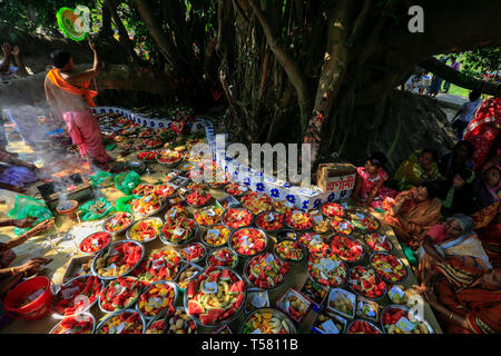 Devoti di sedersi accanto a schiere di offerte di servizi posti sotto le antiche banyan tree, che è adorato dagli Indù locale il primo giorno dell anno bengalese. Na Foto Stock