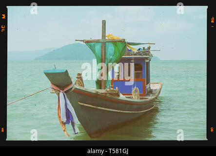 Legno di piccole barche da pesca sulla spiaggia tropicale, film retrò stilizzata Foto Stock