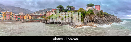 Ampio panorama del porticciolo di Nervi, Liguria, Italia nel tempestoso tempo piovoso visto dal mare sotto un grigio cielo nuvoloso con colorati waterfro Foto Stock