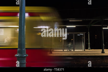 Di notte quando il giallo rosso arriva in treno Foto Stock