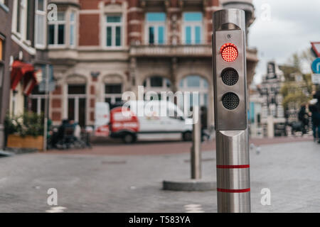 Automatico bollard metallico con luce rossa con la vecchia città sullo sfondo Foto Stock