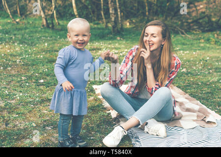 Mom può contenere la figlia della mano, umore giocoso in un bambino, la festa della mamma Foto Stock