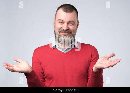 Uomo che mostra non ho idea del gesto, scrollare le spalle e alzando le mani Foto Stock