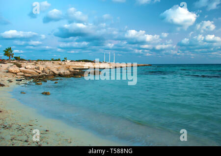 Immagine di splendida Landa spiaggia di Agia Napa, Cipro. Giallo sabbia e massi contro blu acqua calma in una serata calda in autunno, Piccole nuvole in th Foto Stock