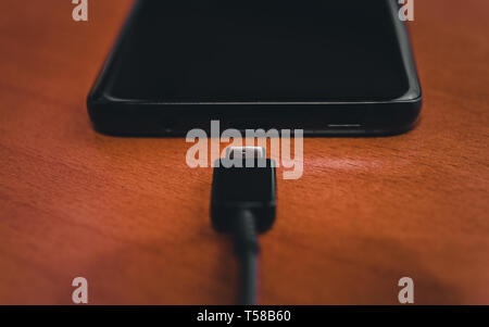 Close up di nero la ricarica dello smartphone Foto Stock