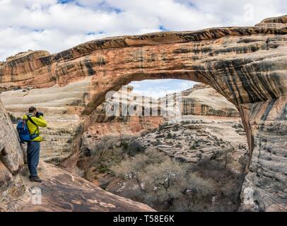 Tourist, escursionista fotografando arch rock, Sipapu Bridge, ponti naturali monumento nazionale, Utah, Stati Uniti d'America Foto Stock