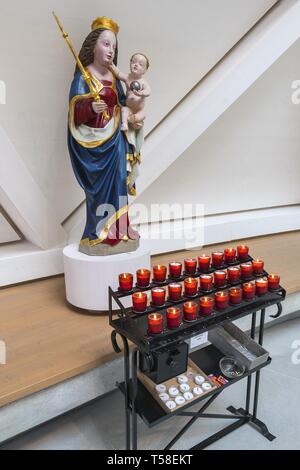 La figura di Madonna con Gesù Bambino e candele sacrificale, chiesa Sankt Joseph, Holzkirchen, Alta Baviera, Baviera, Germania Foto Stock