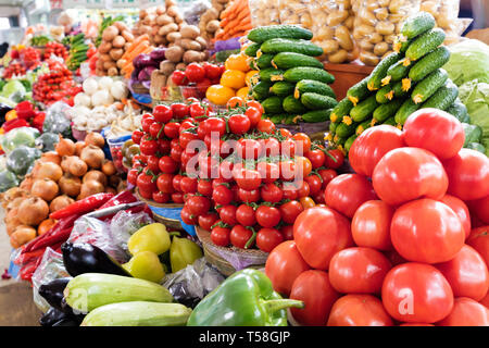Rami di pomodori ciliegini, cetrioli, peperoni, melanzane, Cipolle Cavolo, zucchine e altri ortaggi per la vendita sul mercato Foto Stock