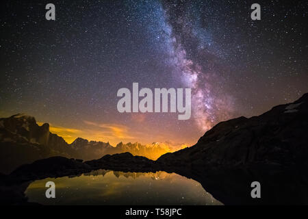 Via Lattea e il cielo stellato su iconico innevate vette del Monte Bianco riflettente nel lago di altitudine (Lac Blanc) Foto Stock