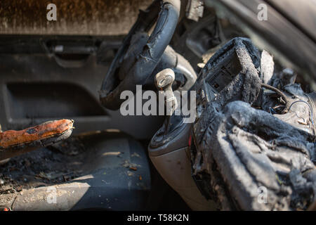 Vista interna del bruciato relitto di un furto di auto. Scena del Crimine immagine dell'interno del veicolo ha rovinato da un incendio o arson. La plastica fusa e metallo e steerin Foto Stock