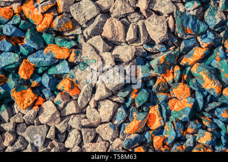 Abstract sfondo grigio di pietre e rocce ricoperte con vernice rossa, vista da sopra Foto Stock