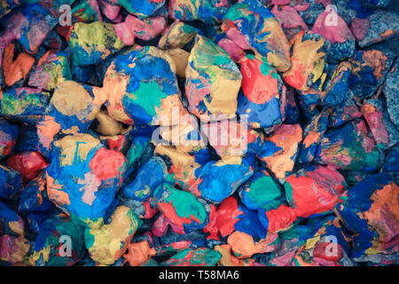 Ciottoli lucido verniciato vernice colorata. Stony superficie coperta con diversi colori. Abstract linea piatta dello sfondo. Foto Stock