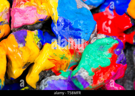 Abstract sfondo luminoso con pietre colorate con della vernice, bizzarro per la diffusione di vernice sulla superficie Foto Stock