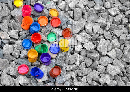 Vasetto da sotto la vernice di diversi colori su una pietra grigia, vista da sopra Foto Stock