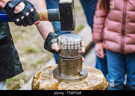 Lavorare il metallo con un martello sull'incudine nella forgia. Colpire il  ferro all'aperto in officina con il fuoco. Lavorazione dei metalli, fabbro  Foto stock - Alamy