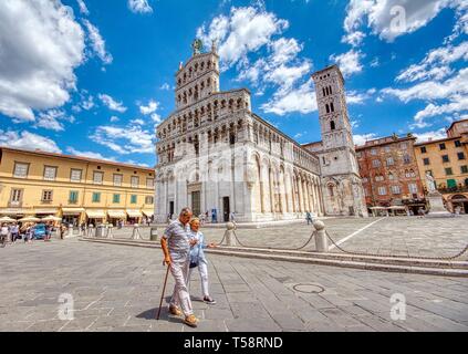 Lucca, Italia - 26 Giugno 2018: Vista della cattedrale medievale di San Michele a Lucca, Italia. I turisti a piedi attraverso il centro storico di Lucca. Foto Stock