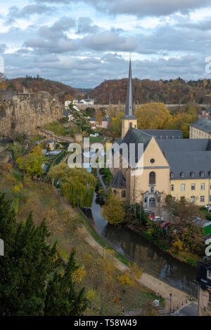 Vista dalla città alta al St Jean de Grund chiesa e monastero accanto al fiume Alzette e con il treno Adolphe ponte in background Foto Stock